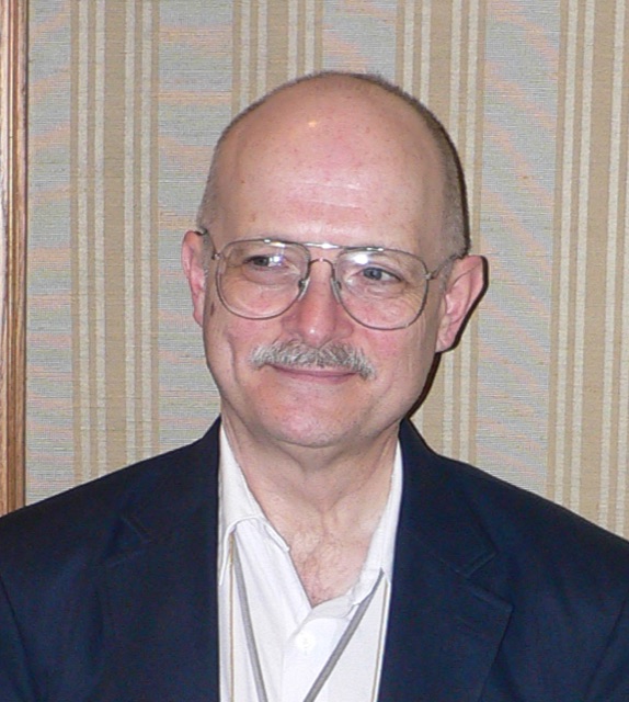 Vernor Vinge, smiling, with a grey beard and glasses